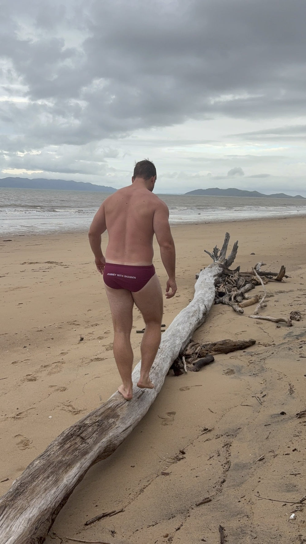 Back view of Shannon wearing Burgundy JWS swim briefs