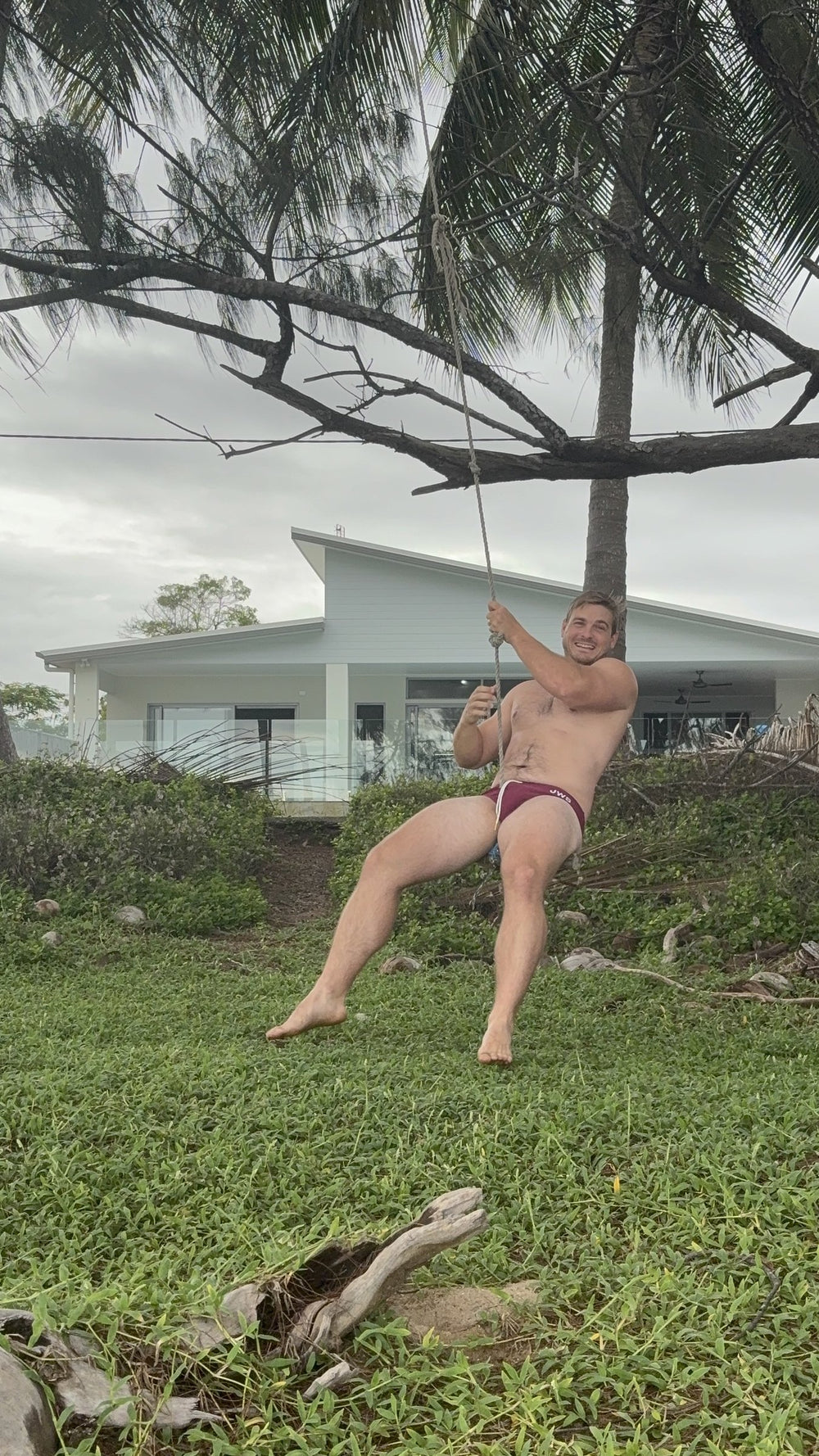Shannon wearing Burgundy JWS swim briefs on a rope swing