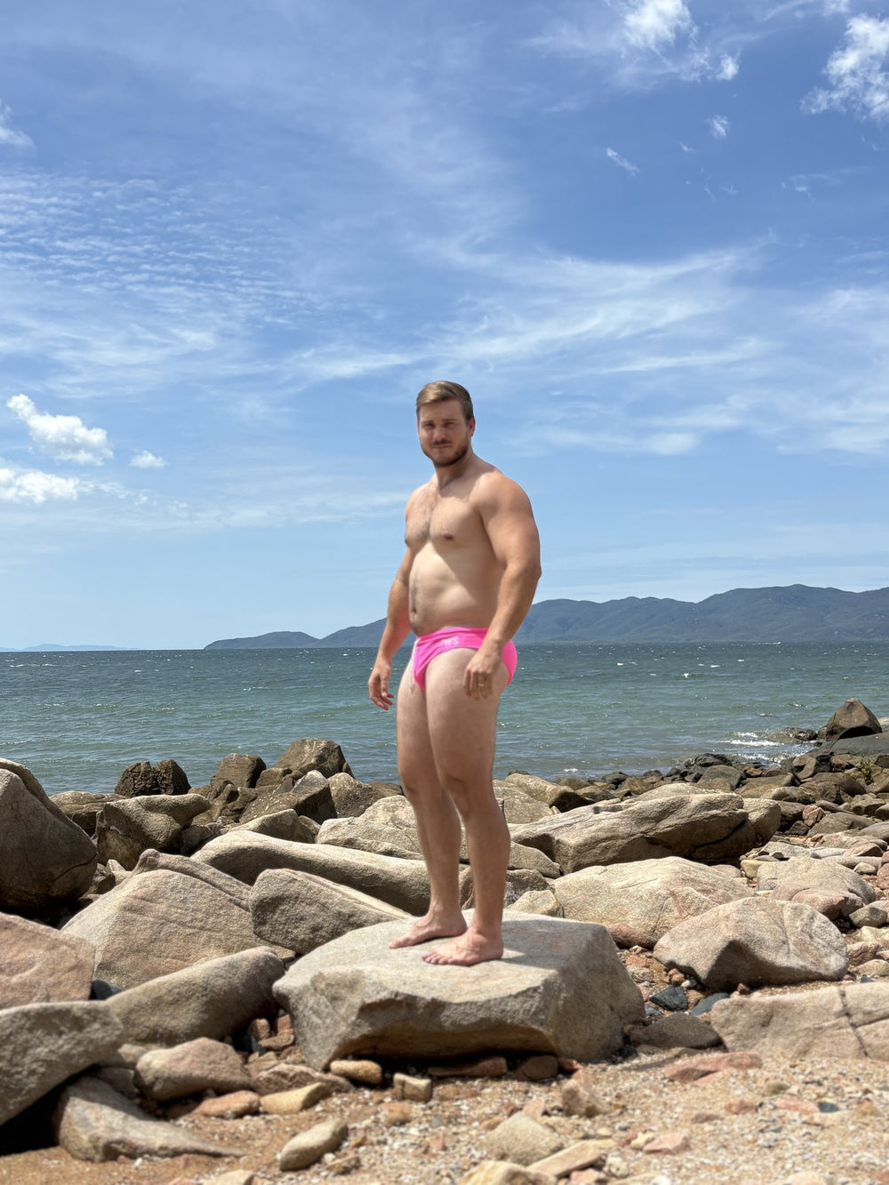 Shannon wearing Hot Pink JWS swim briefs on coastal rocks